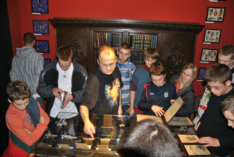  Founder Piotr Wojciechowski and school-aged guests in Eastern Europe&rsquo;s first tattoo museum, in Poland.